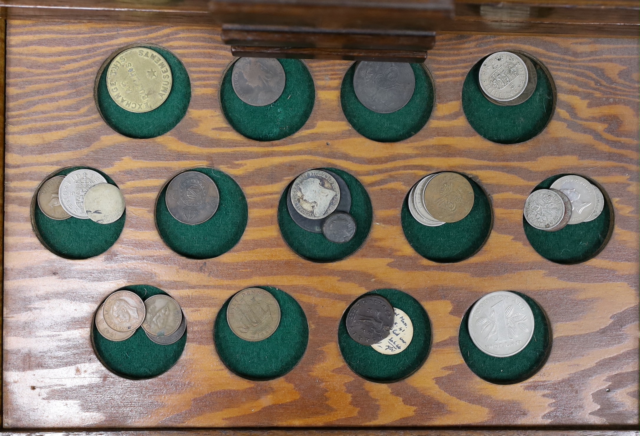 A collection of mixed coinage in a collectors cabinet, 27cm tall